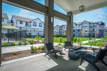 A patio with a table and chairs overlooks apartment buildings.
